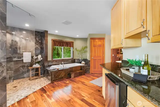 Magnificent walk in shower of marble, rock, glass doors, and large jetted tub. Refer to chill your beverages, separate toilet room and primary closet.