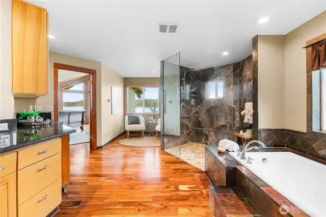 Looking towards the water there is a sitting room next to the walk in shower. Built in cabinets and double sinks.