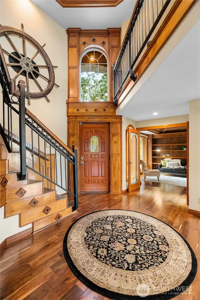 Entry looking at the 8' Ships Wheel from the Multnomah one of the Mosquito Fleet Vessels from the 1920's. It actually spins on the wall. Check out the den off the entry with double fireplace see through to the living room.