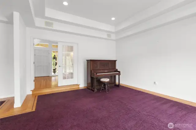 Formal living room off entry with French doors, tray ceiling and hardwood inlay perimeter.