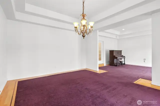 Formal dining room with tray ceiling and decorative hardware inlay perimeter.