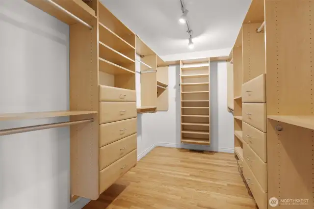 Primary bedroom custom walk-in closet with tons of storage.