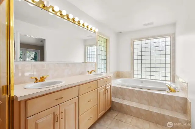 Primary bathroom with jetted tub, double vanity and walk-in shower.