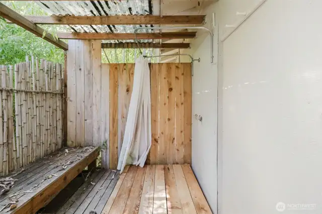 Adding to the studio’s rustic-luxe appeal, a private outdoor shower is tucked behind the building—surrounded by a fence and a couple of swaying bamboo plants. It’s the perfect spot to rinse off under the open sky, blending a sense of adventure with everyday comfort. A little touch of resort-style fun, right in your own backyard!