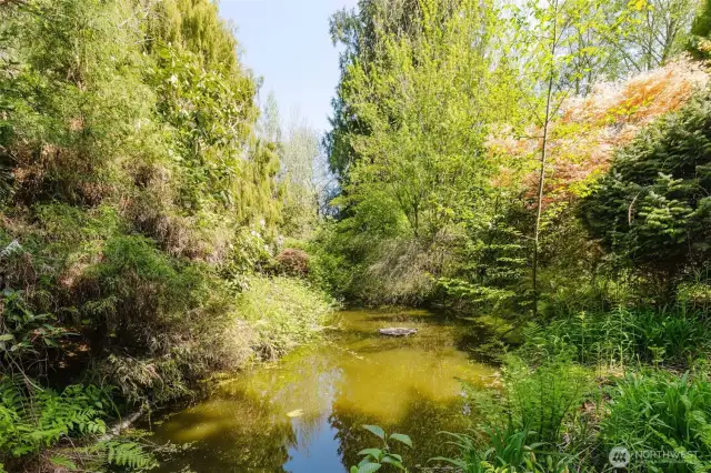 A peaceful pond and seasonal stream add to the natural charm, inviting wildlife and moments of quiet reflection. The charming pond with a concrete border adds a peaceful focal point to the grounds. Once the centerpiece of the garden, it features a decorative fountain that was recently uncovered. While the fountain currently shuts off intermittently—likely needing%
