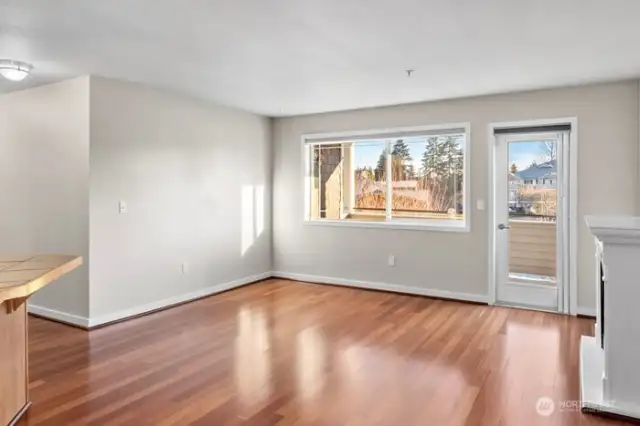 Spacious living room with gleaming hardwood floors and fireplace.