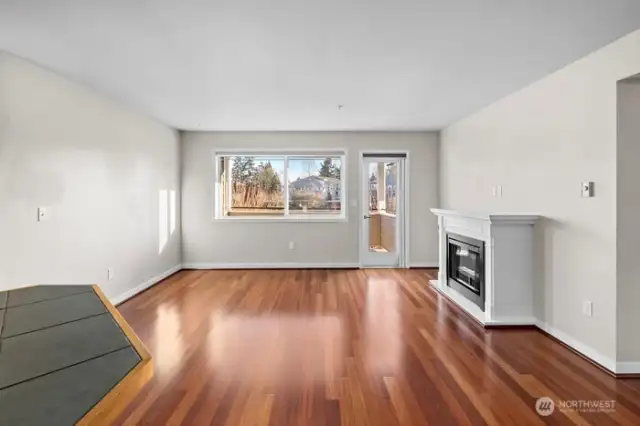 Spacious living room with gleaming hardwood floors and fireplace.