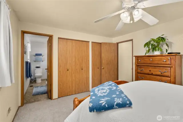 Primary bedroom with 2 closets, an ensuite bathroom, plus new carpet.