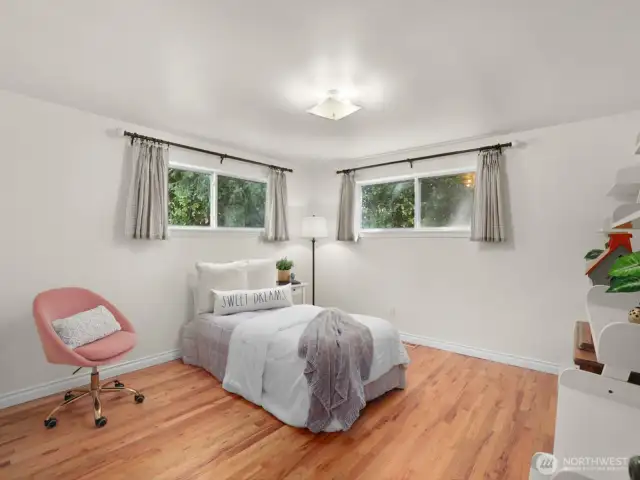One of two well-sized bedrooms grace the main level, both filled with natural light and charming details.