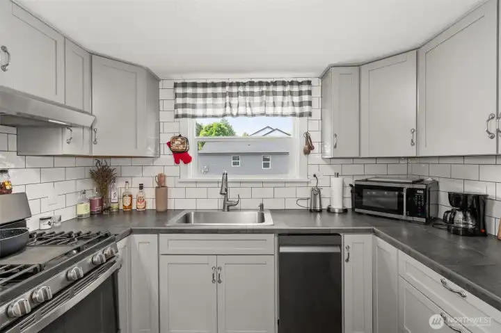 Gas stove and subway tile that wraps the whole kitchen.