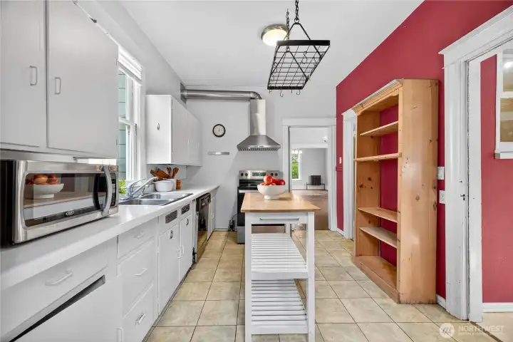 Kitchen view with convenient access to laundry and powder room, plus open sightlines back toward the dining area.