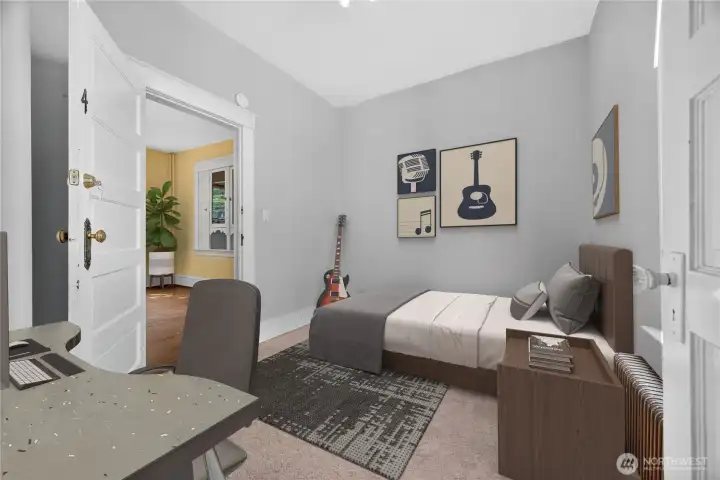 Main floor bedroom with generous natural light and open view toward the dining room. (Virtually Staged.)