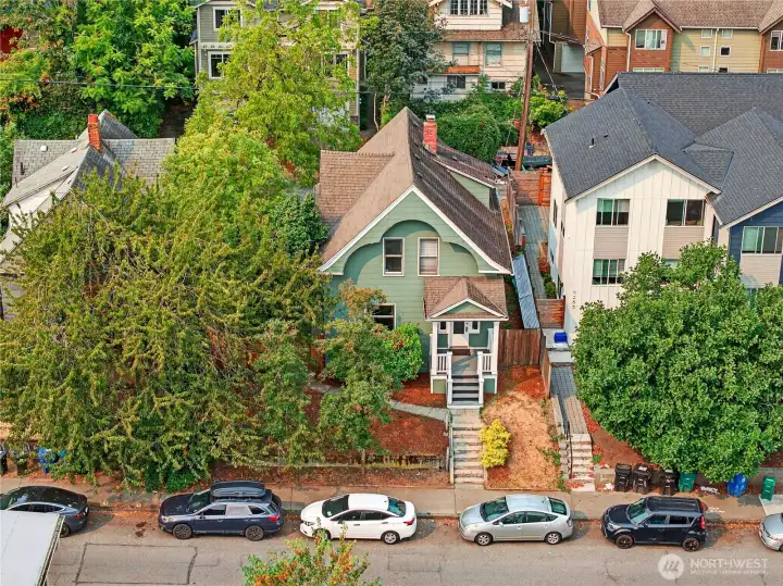 Aerial view of the front of the home, highlighting ample on-street parking and off-street parking in the rear.
