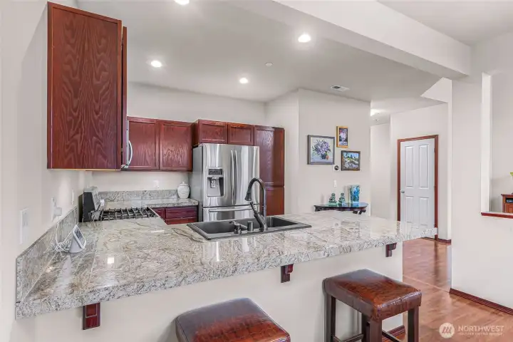 Kitchen offers granite tile counter tops, newer stainless steel appliances and a gas range.