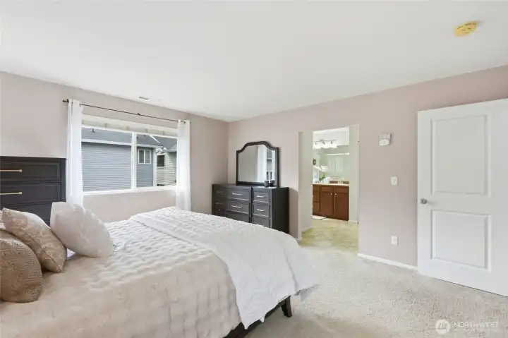 Primary Suite Spacious primary bedroom featuring plush carpeting, large windows, abundant natural light, and a private ensuite bath for added comfort and convenience. Primary Suite Spacious primary bedroom featuring plush carpeting, large windows, abundant natural light, and a private ensuite bath for added comfort and convenience.