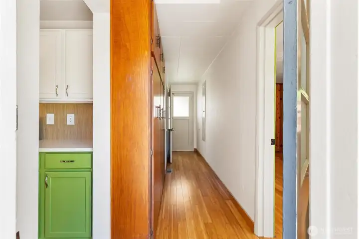 A bank of floor-to-ceiling storage in the hallway leading to the backyard and basement door.