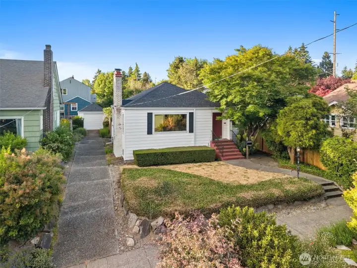 Welcome home to this enchanting Cape Cod-style residence, perfectly situated in one of Seattle’s most coveted neighborhoods. Radiating timeless appeal, this 2-bedroom, 2-full-bath home beautifully preserves its original character and charm while offering the modern updates you desire—including a brand-new roof for total peace of mind. Step inside to discover a warm, inviting main level showcasing gorgeous original hardwood floors and a classic gas fireplace. Downstairs, a second wood-burning fireplace creates the ultimate cozy retreat for chilly Seattle evenings. The thoughtful layout also includes a spacious primary bedroom complete with a rare and generous walk-in closet. One of the property's standout features is its expansive 5,150-square-foot lot. The large, fully fenced backyard serves as your own private oasis—entertaining, or letting pets roam freely. ?Location is everything, and this home delivers an unparalleled Pacific Northwest lifestyle.