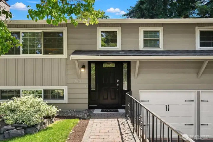 This close-up of the front entry showcases the home's updated exterior with fresh paint, a welcoming covered porch, and lush greenery framing the approach. This close-up of the front entry showcases the home's updated exterior with fresh paint, a welcoming covered porch, and lush greenery framing the approach.