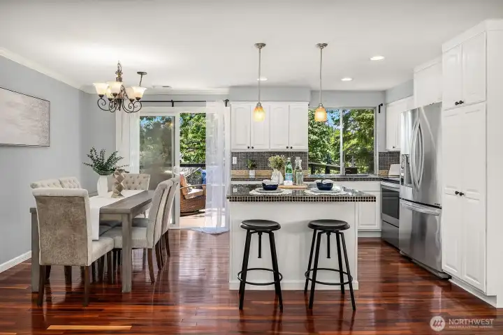 The chef-style kitchen shines with freshly updated cabinetry, island seating, and pendant lighting, opening beautifully to the dining area and deck beyond. The chef-style kitchen shines with freshly updated cabinetry, island seating, and pendant lighting, opening beautifully to the dining area and deck beyond.
