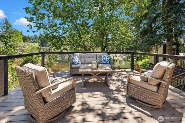 Another view of the deck highlights the comfortable outdoor seating and serene tree-lined backdrop, making this an ideal space for morning coffee or evening entertaining. Another view of the deck highlights the comfortable outdoor seating and serene tree-lined backdrop, making this an ideal space for morning coffee or evening entertaining.