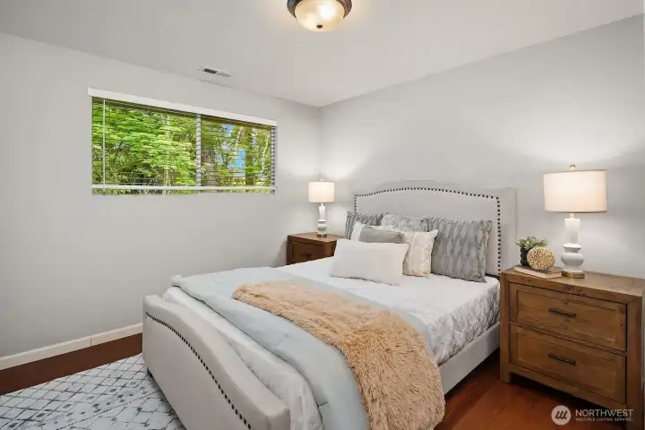 A second view of this bedroom showcases its warm, inviting atmosphere with natural light and hardwood floors, offering a quiet sanctuary for rest and relaxation. A second view of this bedroom showcases its warm, inviting atmosphere with natural light and hardwood floors, offering a quiet sanctuary for rest and relaxation.