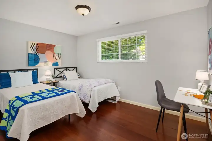 A additional bedroom features rich hardwood floors, a large window filling the space with natural light, and plenty of room for a desk or sitting area, ideal as a guest room or home office. A additional bedroom features rich hardwood floors, a large window filling the space with natural light, and plenty of room for a desk or sitting area, ideal as a guest room or home office.