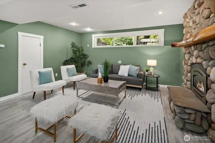 A second view of the lower living room highlights the abundant natural light, stylish finishes, and inviting layout, making this versatile space equally suited for relaxing or entertaining. A second view of the lower living room highlights the abundant natural light, stylish finishes, and inviting layout, making this versatile space equally suited for relaxing or entertaining.