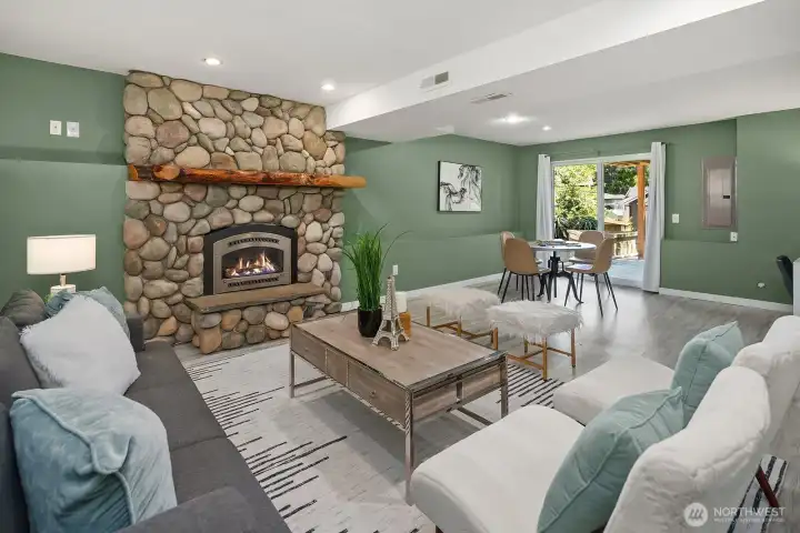 This angle of the lower living room showcases the full beauty of the stone fireplace and the bright doorway beyond, reinforcing the space's warmth and easy flow to the rest of the home. This angle of the lower living room showcases the full beauty of the stone fireplace and the bright doorway beyond, reinforcing the space's warmth and easy flow to the rest of the home.