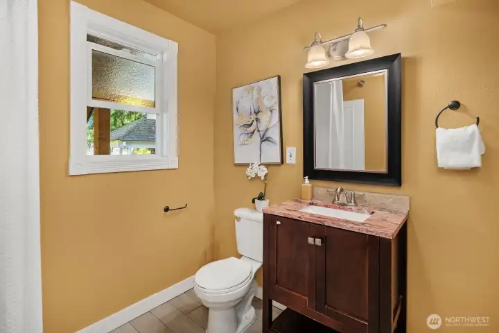 The lower level three-quarter bath features a stylish dark wood vanity, warm tones, and convenient access from the bonus living space below. The lower level three-quarter bath features a stylish dark wood vanity, warm tones, and convenient access from the bonus living space below.