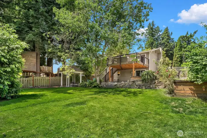 The fully fenced backyard offers a lush lawn, mature trees, and glimpses of the gazebo and entertaining zones beyond, providing a private outdoor oasis for pets, play, and gatherings. The fully fenced backyard offers a lush lawn, mature trees, and glimpses of the gazebo and entertaining zones beyond, providing a private outdoor oasis for pets, play, and gatherings.