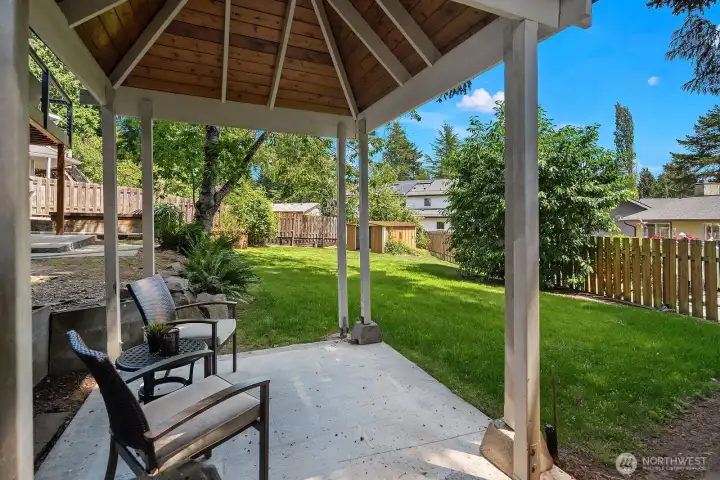 A closer look at the gazebo reveals a spacious patio area with comfortable seating, perfect for shaded outdoor relaxation while overlooking the fully fenced backyard and garden spaces. A closer look at the gazebo reveals a spacious patio area with comfortable seating, perfect for shaded outdoor relaxation while overlooking the fully fenced backyard and garden spaces.