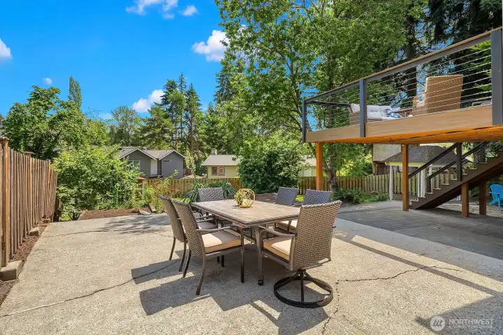 The spacious patio dining area is framed by lush mature landscaping and the striking deck structure above, creating a beautiful and private outdoor setting for al fresco meals and entertaining. The spacious patio dining area is framed by lush mature landscaping and the striking deck structure above, creating a beautiful and private outdoor setting for al fresco meals and entertaining.