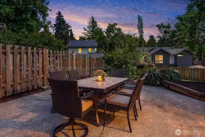 A stunning twilight view of the patio dining area captures the warm evening ambiance, lush surroundings, and inviting atmosphere that make this backyard a true outdoor retreat. A stunning twilight view of the patio dining area captures the warm evening ambiance, lush surroundings, and inviting atmosphere that make this backyard a true outdoor retreat.