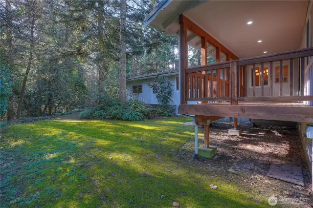 View of covered back deck and established grounds.