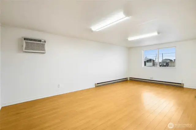 Another view of the family room, with a wall air conditioner, and the vinyl windows face the street and driveway.