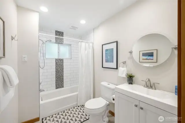 Main floor full bathroom with tub and room for storage.