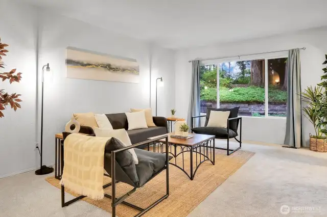 A large picture window offers a stunning view of the lush backyard.