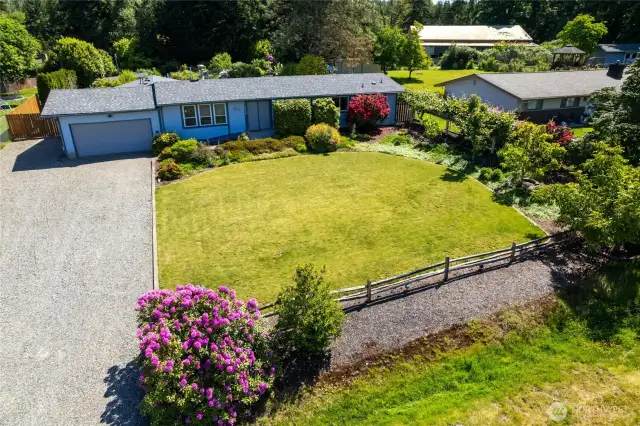 Welcome to this beautifully updated rambler on a serene, park-like .56-acre lot near Lake Youngs. Experience the ease and comfort of single-level living in a home surrounded by nature's beauty. The professionally landscaped yard offers lush greenery, curated garden beds, and an inviting sense of privacy.