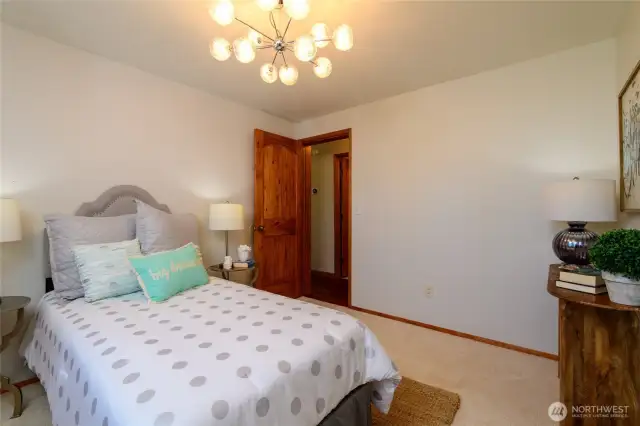 Bedroom #2. Note the custom knotty pine doors and fun light fixture!