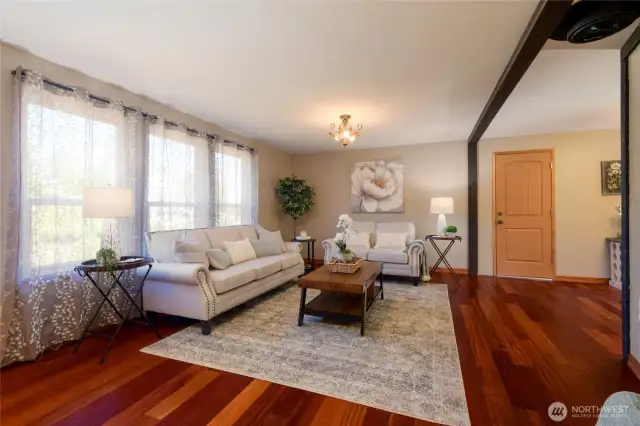 Step into a living room that instantly feels like home. Rich, warm hardwood floors add timeless beauty and a touch of elegance, while the inviting layout creates a cozy atmosphere perfect for relaxing evenings or intimate gatherings.