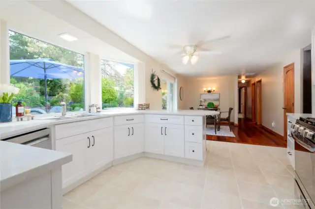 Fall in love with the stunning new kitchen—featuring white, soft-close cabinetry, gleaming quartz countertops, a gas range, ceramic tile flooring, and bright bay windows that flood the space with natural light.