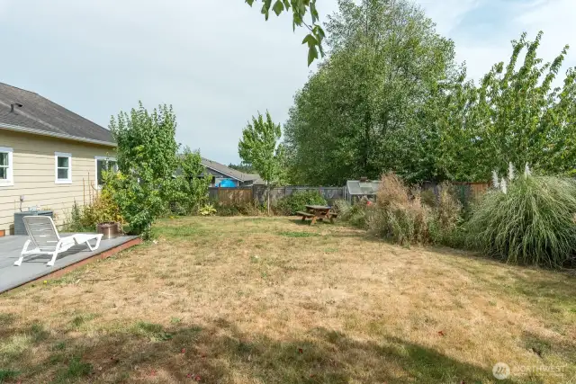 Spacious yard with nice deck, mature landscaping, garden area and greenhouse.