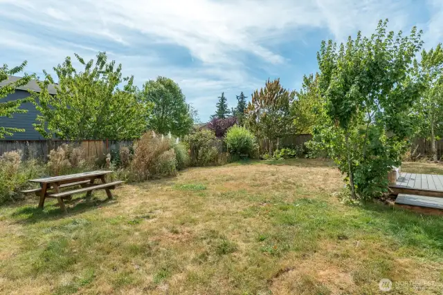 Spacious yard with nice deck, mature landscaping, garden area and greenhouse.