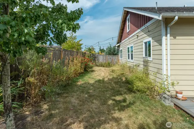 Spacious yard with nice deck, mature landscaping, garden area and greenhouse.