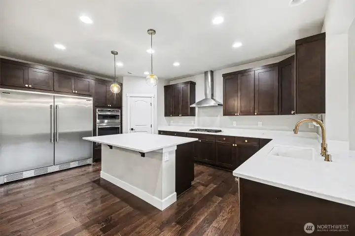 This stunning dream kitchen is the heart of the home! Open and bright with rich warm cabinetry, an open layout to the living room, and plenty of space for gathering—perfect for hosting and everyday living.