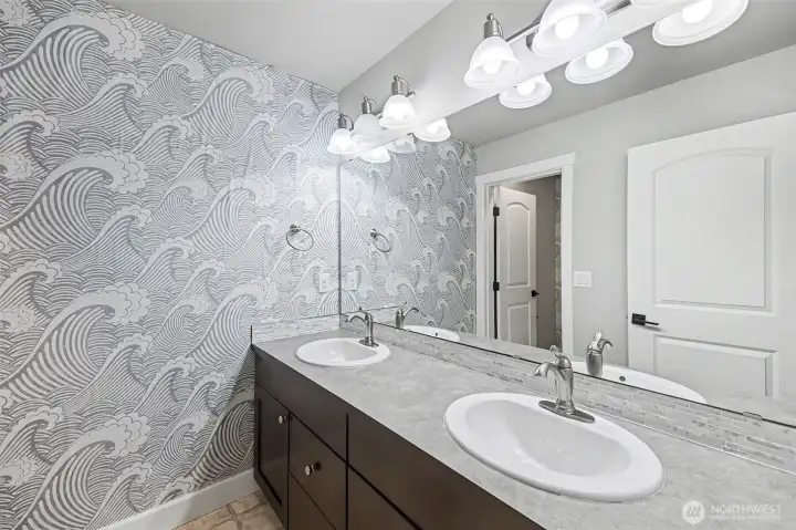 Upstairs full bathroom with dual vanity and calming wall paper.