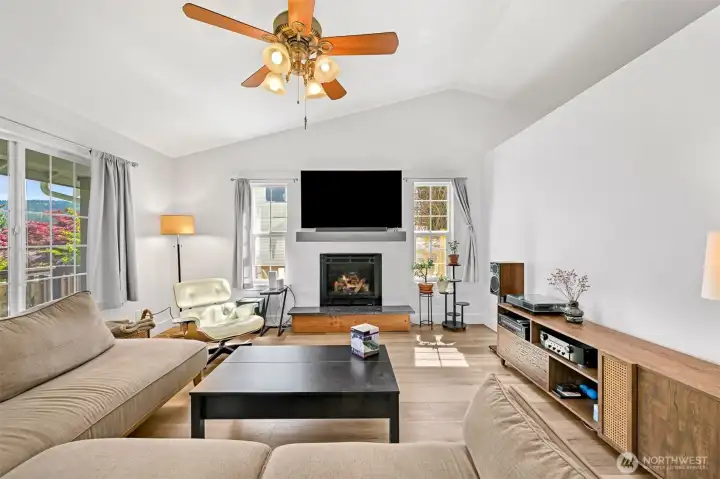 Living room has vaulted ceiling with fan, and a gas fireplace