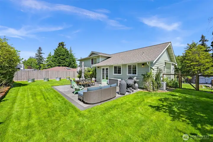 Lush, fully fenced yard has plenty of room for play and four-legged friends