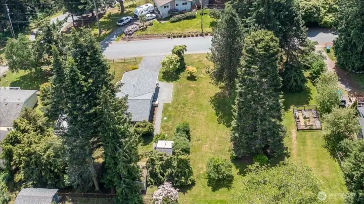 Aerial view of the home and the sideyard allowing you to see how much space is here. You can also view the dedicated garden space.