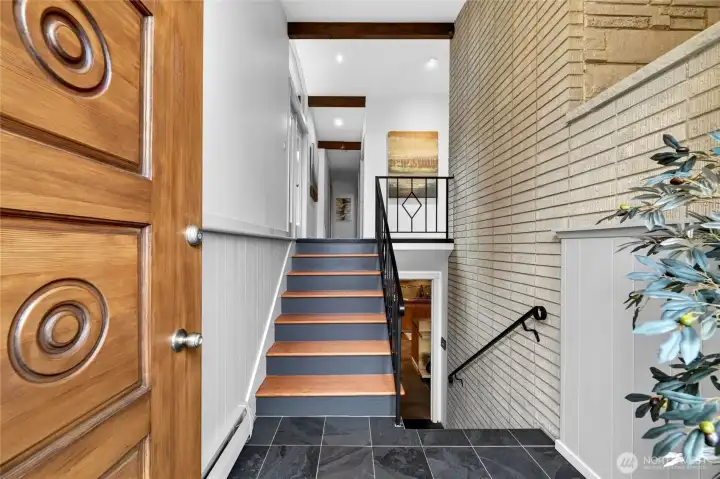 The original door welcomes you into the home with a two story brick and a peek at the exposed beams